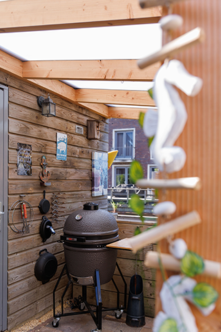 Ingerichte overkapping met BBQ en wanddecoratie